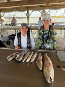 Fresh caught redfish and speckled trout displayed on cleaning station at Matagorda TX fishing dock