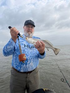 Angler holding speckled trout catch on fishing boat in Matagorda TX waters