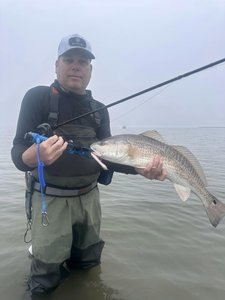 A fisherman proudly holding a 19-inch redfish in TX