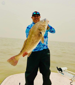 A single fisherman reeling in a big catch at Aransas Pass