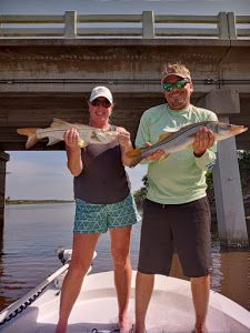 Two anglers with a great catch of two large fish