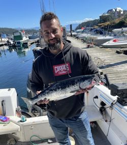 A fisherman holding a 17-inch fish in BC