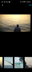 Angler fishing from shoreline at sunset with fishing rod extended over calm water