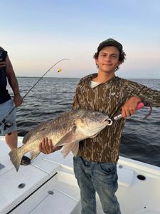 A person fishing for a black drum in Lafitte