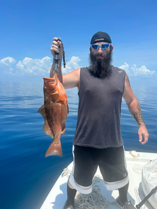 A fisherman holds a red grouper caught in FL