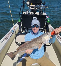 Angler holding a large, 26-inch redfish in Englewood