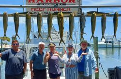 Fishing charter catch display showing mahi mahi and blackfin tuna hanging from boat rigging in Islamorada Florida
