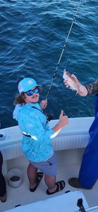 Angler holding fishing rod with caught fish on boat in Gulf Shores AL waters