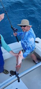 Angler holding fresh caught fish on fishing boat in Gulf Shores AL waters