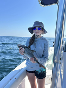 A person fishing on Dauphin Island with a 13-inch catch