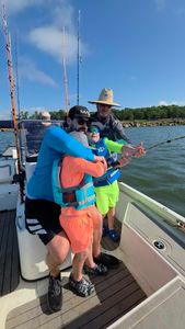 Fishing group working together with rod on charter boat in Glencoe OK waters