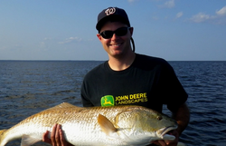 A lone angler reels in a great catch in the waters of Manns Harbor