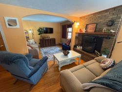 Cozy living room interior with brick fireplace, comfortable seating, and warm lighting in Hale MI