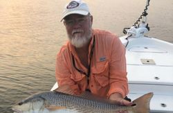 A fisherman holding a large redfish catch at North Topsail Beach