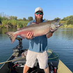 A fisherman reels in a 34-inch rainbow trout in California