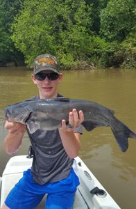 A fisherman reeling in a blue catfish in OK