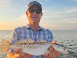 A fisherman holding a spotted weakfish, caught at New Smyrna Beach
