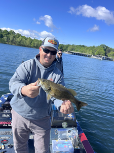 Reeling in the smallmouth bass with expert jigging, bait casting, and tackle techniques under clear skies!