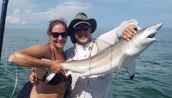 A fisherman holding a large bull shark caught in Galveston