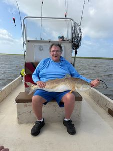 Angler holding large redfish on fishing boat in Matagorda TX waters