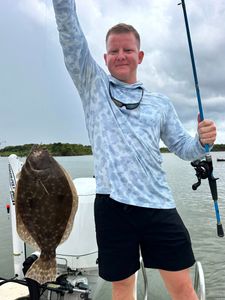 A fisherman holds a summer flounder caught fishing in Matagorda