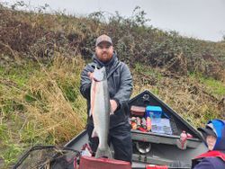 Fisherman holding a large rainbow trout in Myrtle Creek