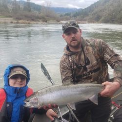 A person fishing for a large rainbow trout in OR