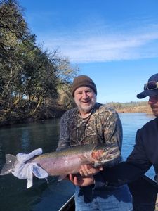 Angler catching a vibrant rainbow trout at Myrtle Creek