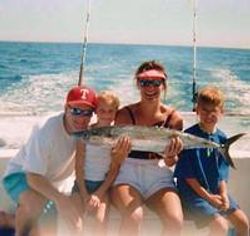 Three people on a boat enjoying a fishing tour in Orange Beach