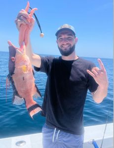 Fisherman with rod reeling in a 19-inch catch at location 33036