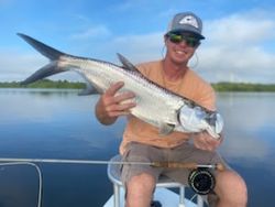 A single fisherman holding a large fish caught in Tarpon Springs