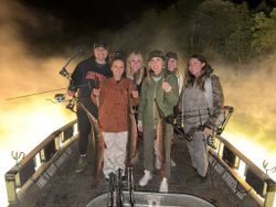Group of anglers displaying caught shortnose gar fish on wooden dock in Tulsa Oklahoma