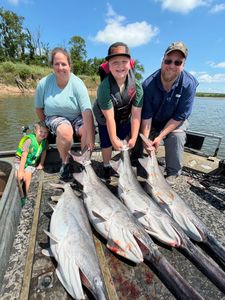 Family fishing trip in Tulsa OK displaying multiple large fish catch on boat deck
