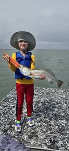 Angler holding caught fish on boat deck in Rockport TX waters