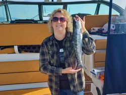 A fisherman catching a European seabass in MI