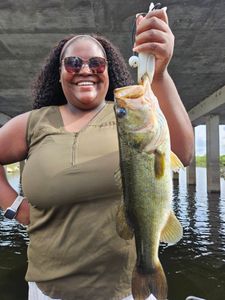 Angler displaying caught bass while fishing under bridge in South Bay FL