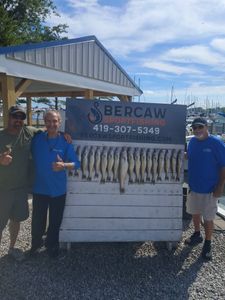 Fishing charter display board showing multiple caught fish at Port Clinton OH marina with boats in background