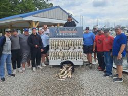 Large group of freshly caught fish displayed on cleaning station at Port Clinton OH marina with fishing charter sign