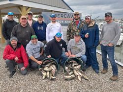 Fishing group with caught fish displayed in buckets at Port Clinton OH marina