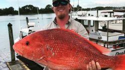 A fisherman holding a 31-inch catch in FL