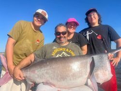 Group of 4 people fishing on the beach in Sand Springs