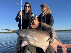 A group of 3 people fishing at a sandy beach location in Sand Springs