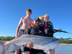 A group of 4 people fishing on the sandy shore in Sand Springs