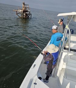 Fishing boat with anglers casting lines near offshore structure in Bay St. Louis MS waters