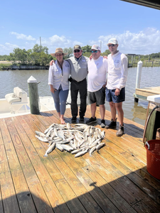 Four people fishing on the shore of Bay St. Louis