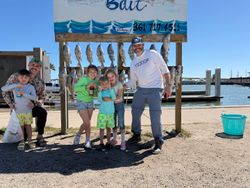 Family fishing trip displaying caught fish at cleaning station in Rockport TX marina