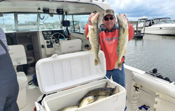 A single person fishing for two large fish at the lakeside in Marblehead