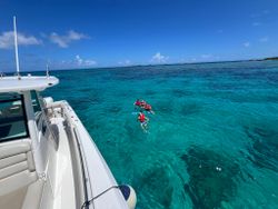 Crystal clear turquoise waters with snorkelers exploring near a white boat in Lake Park FL