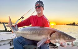 Angler fishing for mighty lake sturgeon in Michigan