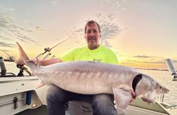 Two anglers fishing for a white sturgeon in Michigan